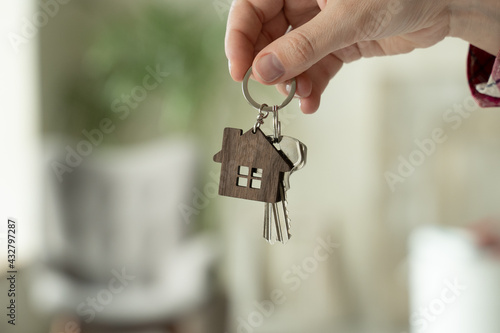 Close-up of a woman's hands holding the keys to a new house, a woman moves into a new apartment