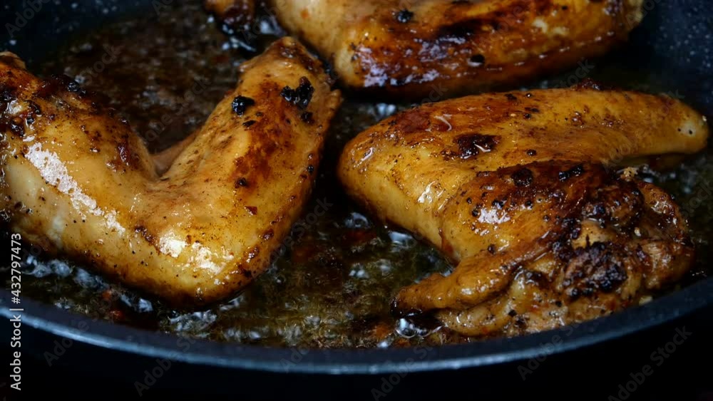 Chicken wings pickled in spiced fried in frying pan until golden brown in boiling vegetable oil. Tasty domestic kitchen or street food. Close-up. Chicken wings pickled in spiced fried in frying pan until golden brown in boiling vegetable oil. Tasty domestic kitchen or street food. Close-up.