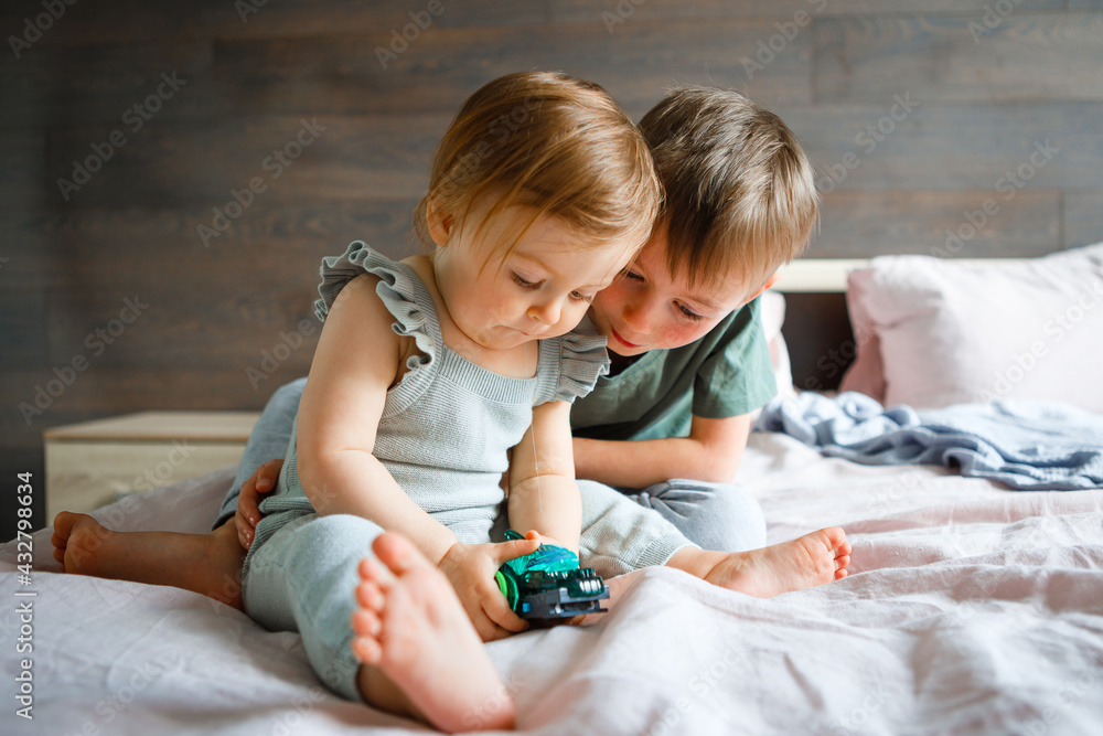 The little sister plays with her older brother at home. The little sister plays with her older brother at home.