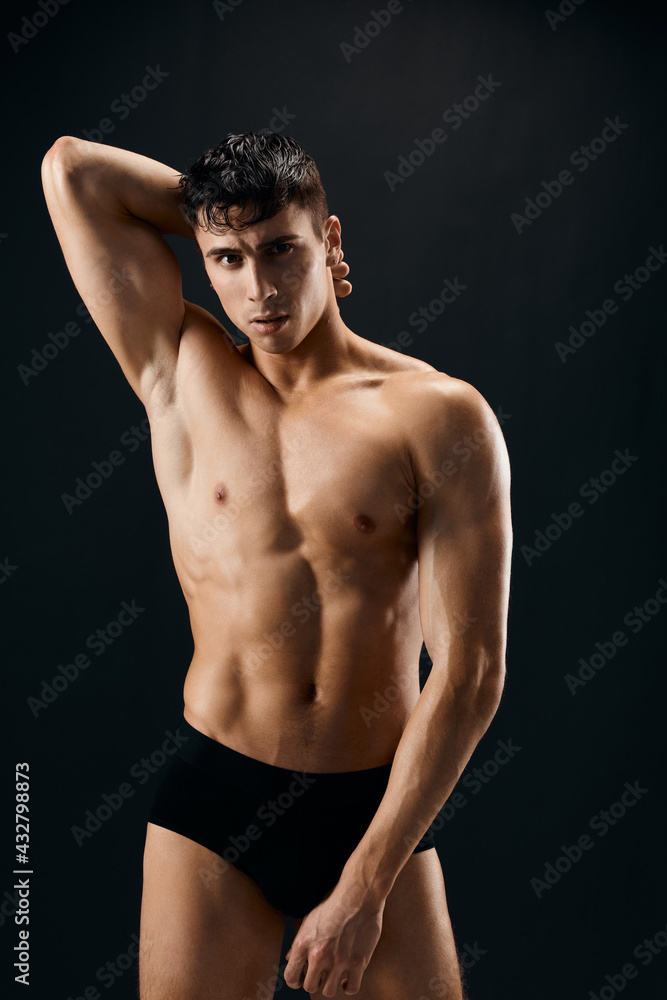 Fototapeta premium man with a pumped-up muscular body holds his hand on his head close-up