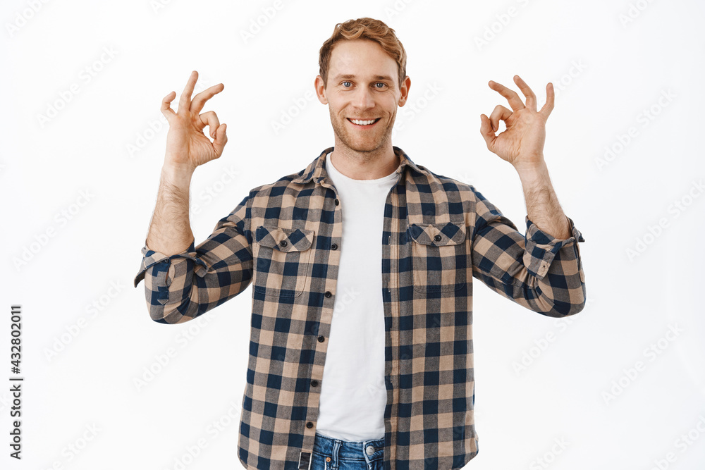 Confident adult redhead man showing yes OK okay gesture and smiling happy, guarantee everything under control, no problem, alright gesture, nod in approval, praise good quality, white background Confident adult redhead man showing yes OK okay gesture and smiling happy, guarantee everything under control, no problem, alright gesture, nod in approval, praise good quality, white background