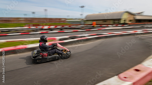 A panning shot of a racing kart as it circuits a track.