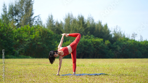 asian chinese female lady yogi practise yoga stretches poses in the park in beautiful weather