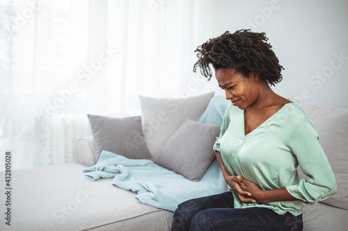 Konstfotografi Closeup shot of a woman suffering with stomach cramps at home
