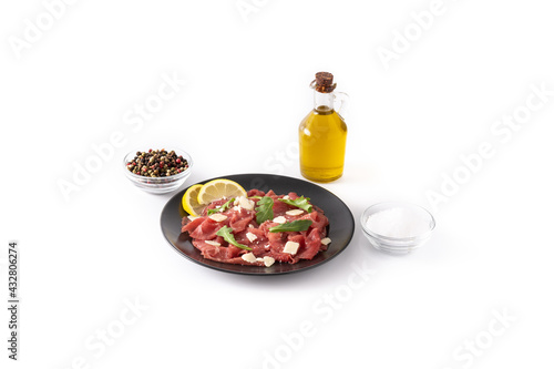 Marbled beef carpaccio on black plate isolated on white background
