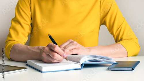 a woman writes down information with a pen in a diary, concept