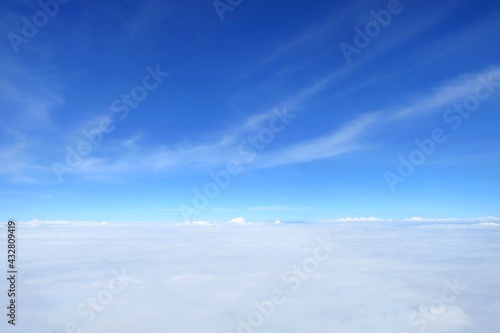 Clear blue sky with white cloud in summer time. Aerial view from airplane's window. Nature background concept with copy space.
