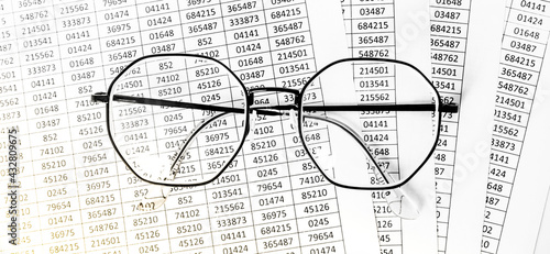 Worksheets or reports showing figures through eye glasses. closeup glasses on financial report. Accounting. financial data. Concept of Business and Finance research. background banner