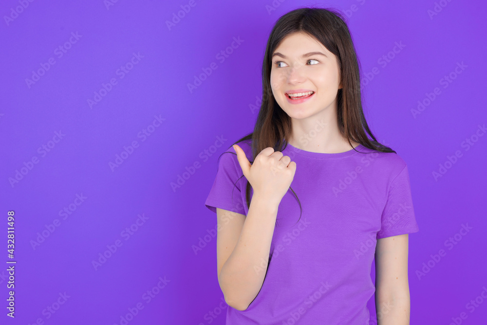young beautiful Caucasian girl wearing purple T-shirt over purple background points away and gives advice demonstrates advertisement young beautiful Caucasian girl wearing purple T-shirt over purple background points away and gives advice demonstrates advertisement