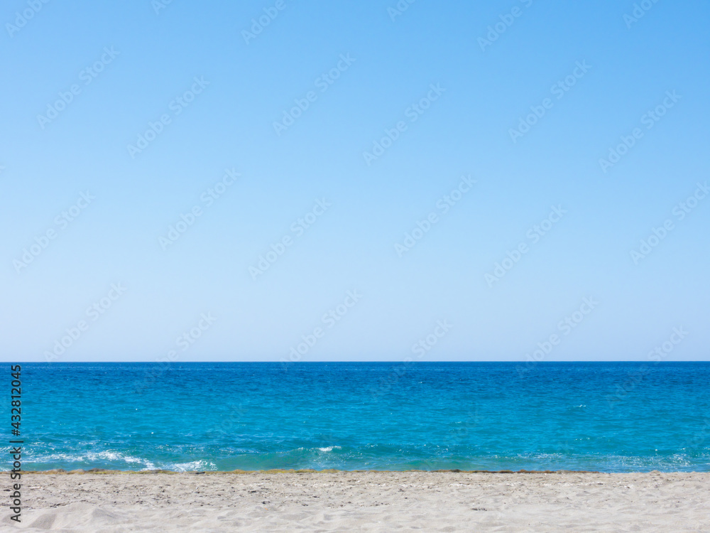 Summer mediterranean beach background. Horizon with calm sea, clear sky and grey sand