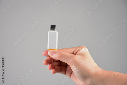 Hand and white usb flash drive isolated on the white background
