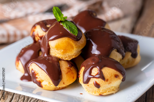 Canvas Print Delicious profiteroles with chocolate and white plate