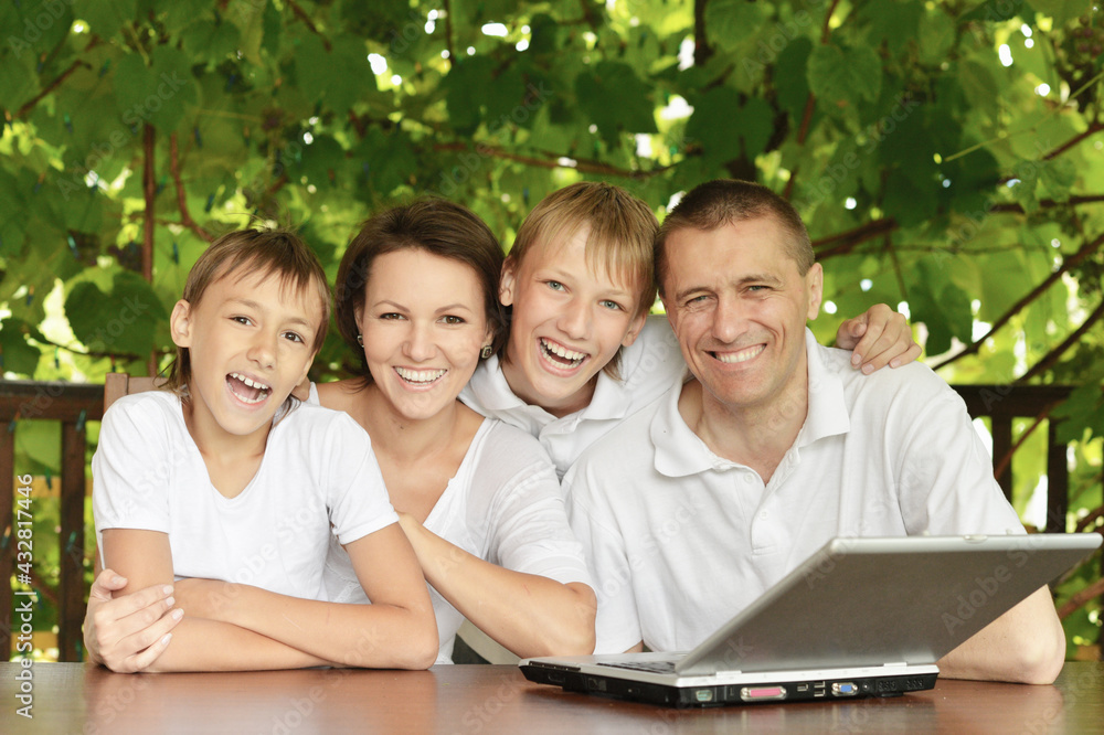 Happy family with laptop in summer Happy family with laptop in summer