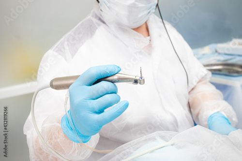 the dentist holds the instrument during the dental implant surgery