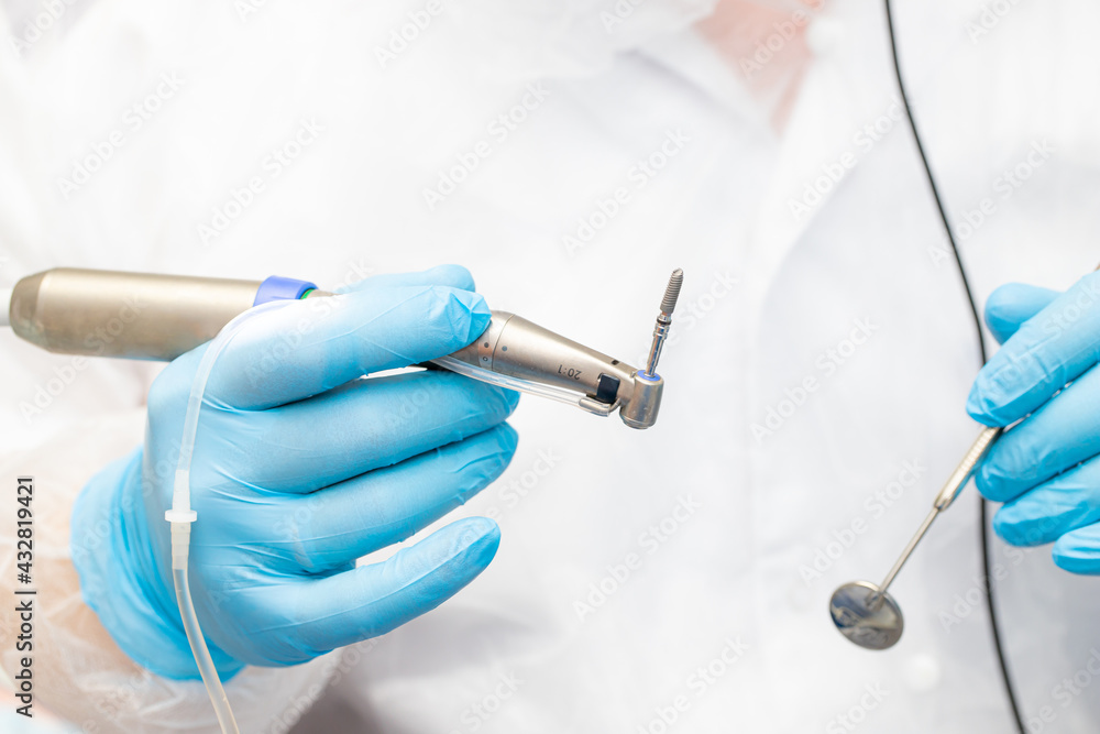 the dentist holds the instrument during the dental implant surgery the dentist holds the instrument during the dental implant surgery