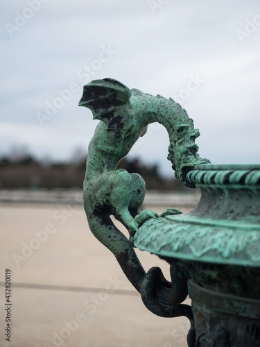 Closeup of dragon figure statue bronze vase fountain decoration in Parterre du Midi Versailles castle gardens France