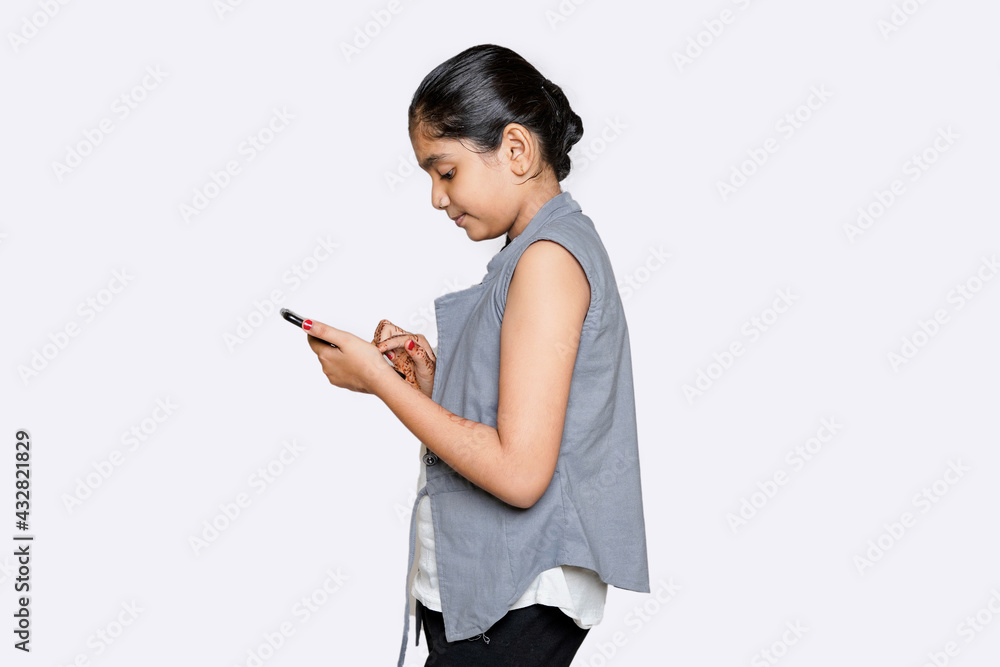 indian Female child using smart phone on white background indian Female child using smart phone on white background