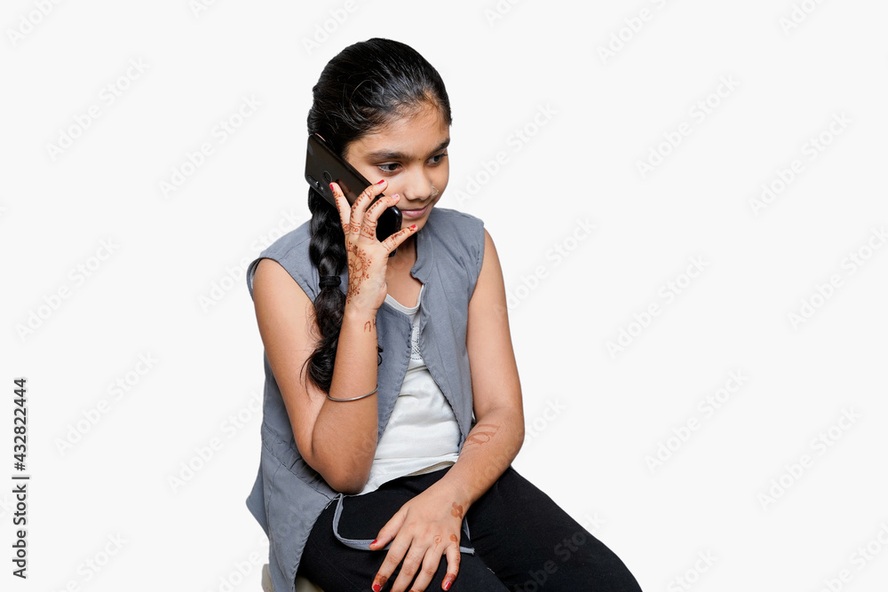 indian Female child using smart phone on white background indian Female child using smart phone on white background