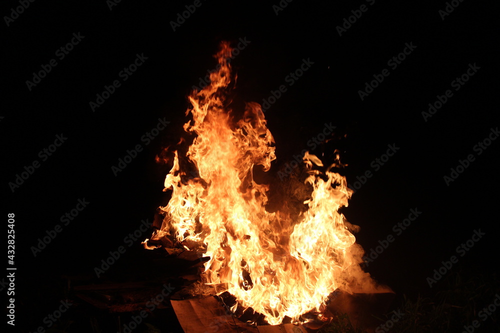 Obraz premium Fire in the night on the wreckage of household items