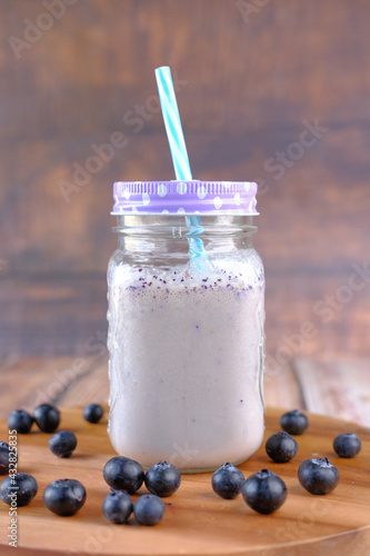 blue berry milk shake in a glass on table 