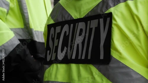 A security guard watching and patrolling a street in a city.