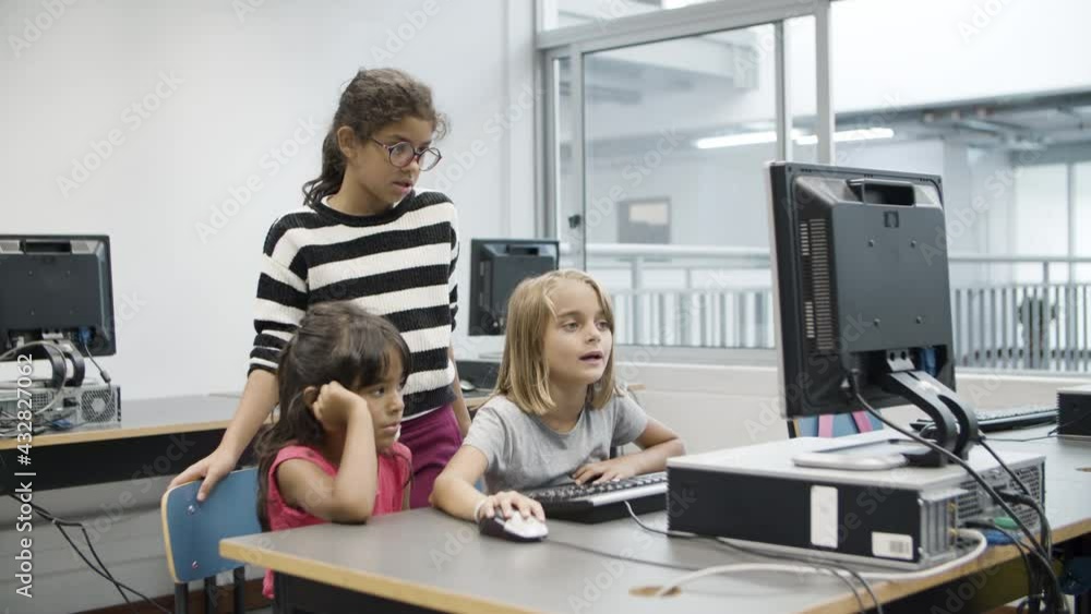 Computer Vs Girl Multiethnic girls looking at computer monitor during class. Blonde girl ...