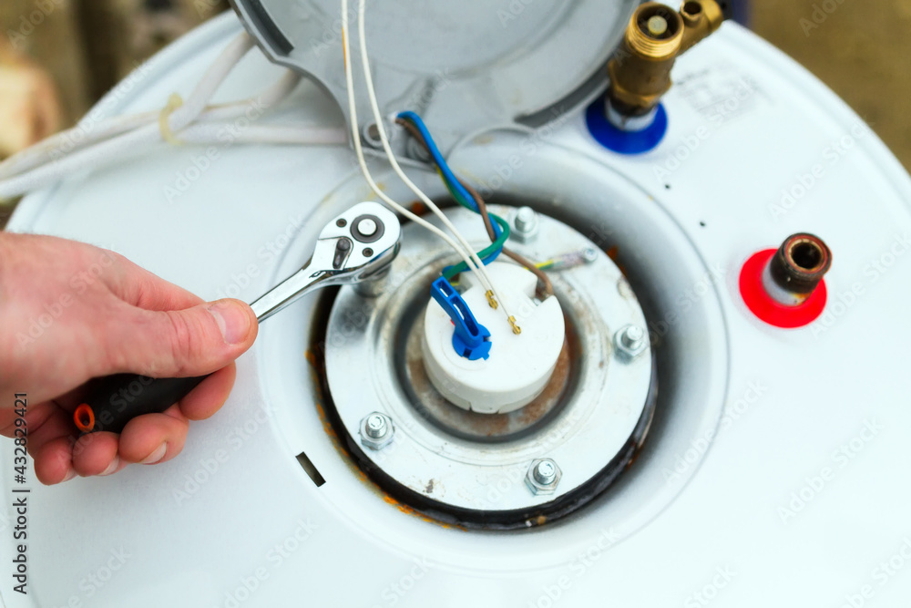 Water heater being repaired with wrench