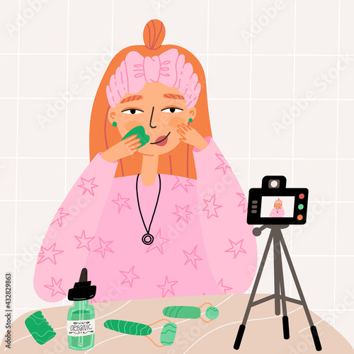Blogger girl shows her beauty routine with gua sha scraper and face serum and record process on digital camera.