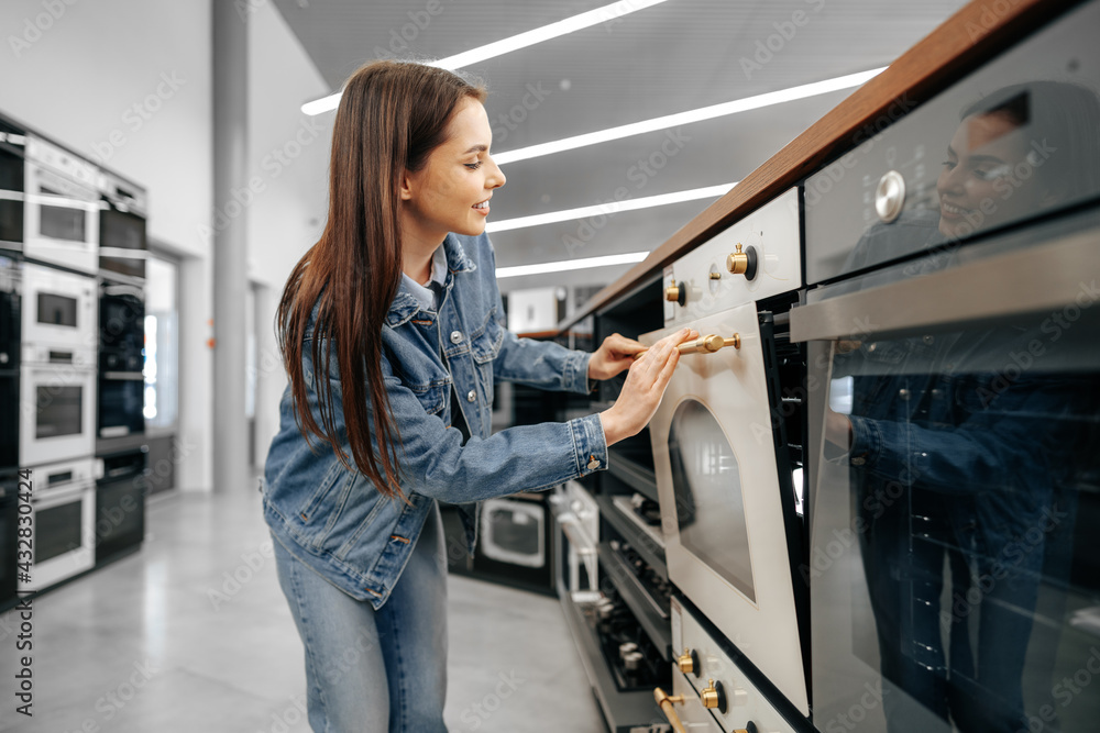 Young woman looking for new electric oven in a shopping mall Stock ...