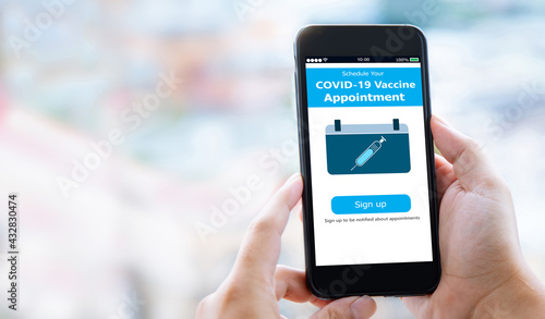 COVID-19 Vaccine sign up appointment concept.Hands holding mobile phone