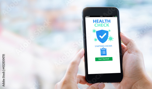 HEALTH CHECK COVID-19 Symptoms checker mobile application concept.Man hands holding mobile phone