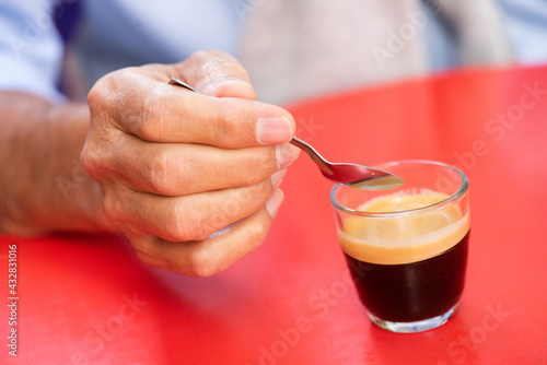 Close up hand with spoon and hot beverage coffee