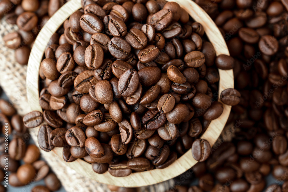 Coffee beans in wooden bowl on sackcloth Coffee beans in wooden bowl on sackcloth