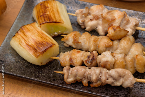 skewered chicken and green onions on a plate, Yakitori