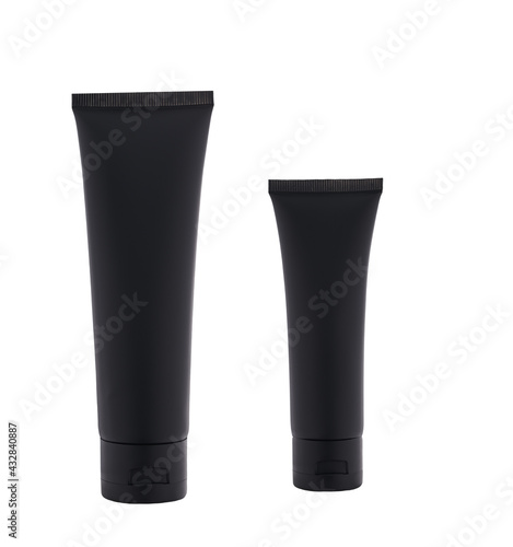 two black plastic bottles with night cosmetic cream or moisturizing lotion isolated on white background.