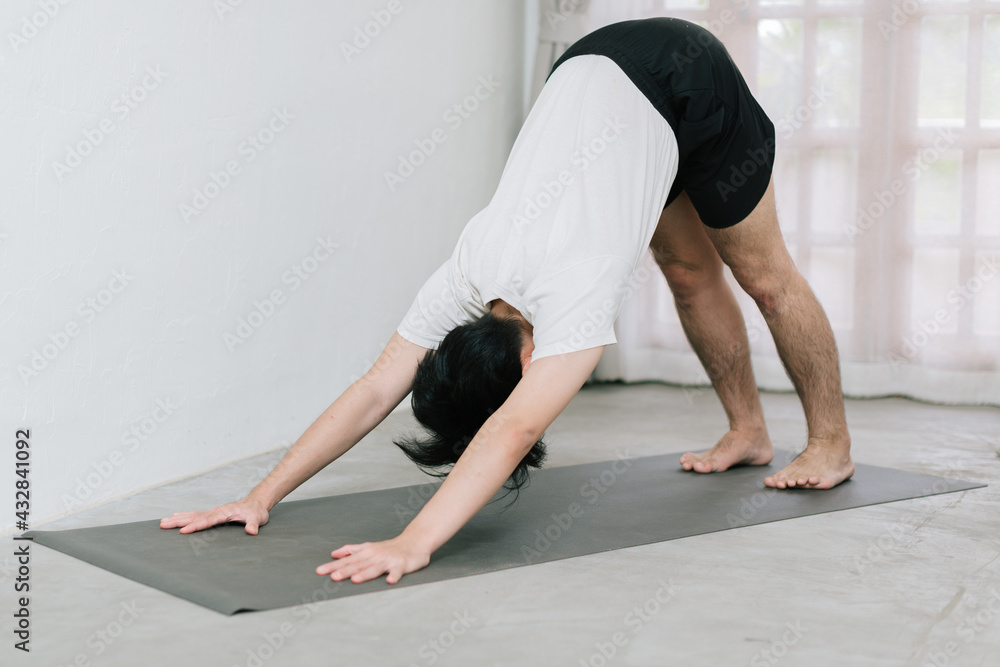 Asian young man doing yoga at home Asian young man doing yoga at home