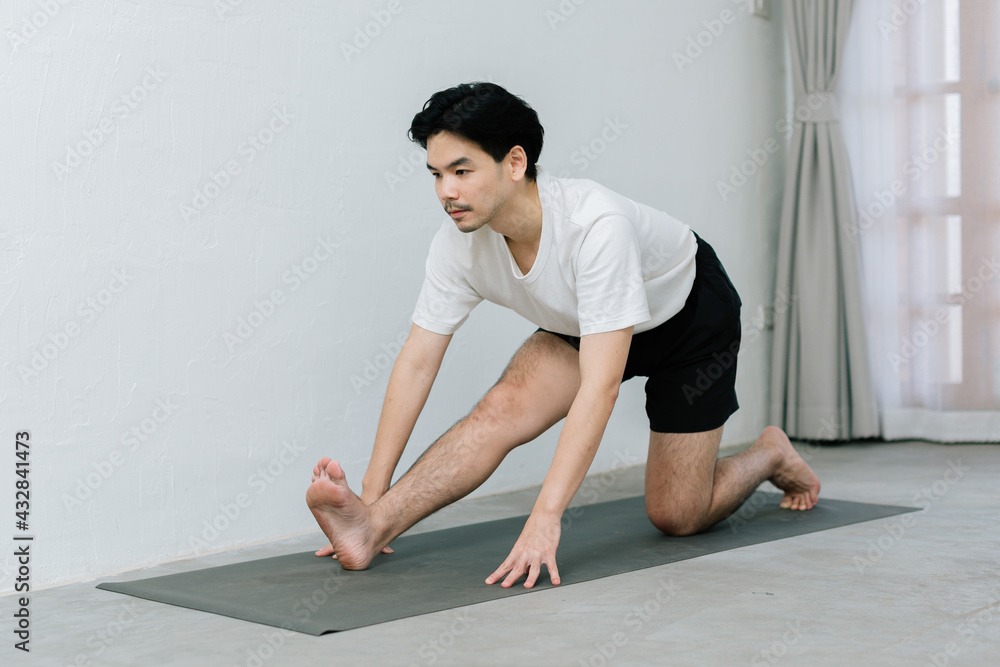 Fototapeta premium Asian young man doing yoga at home