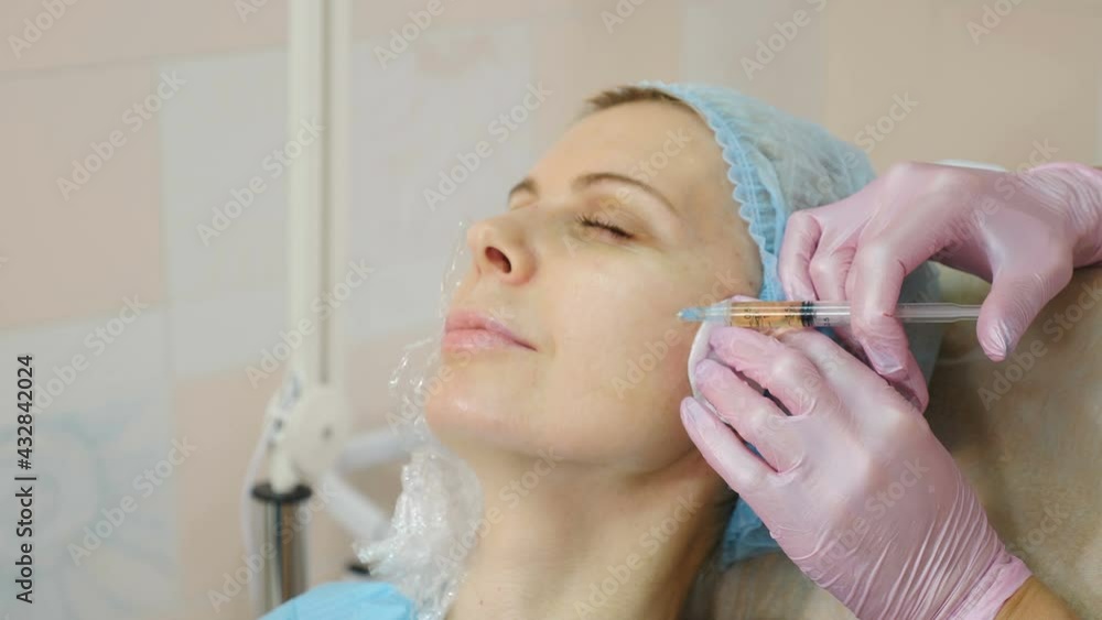 Beauty injection procedure in modern beauty clinic. injection with syringe into female cheek. Beautician performing mesotherapy and face lifting treatment in beauty salon. 4 k video Beauty injection procedure in modern beauty clinic. injection with syringe into female cheek. Beautician performing mesotherapy and face lifting treatment in beauty salon. 4 k video