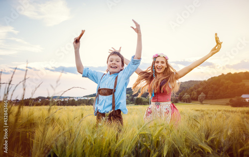 Happy Mother and Son in Bavaria jumping in a meadow