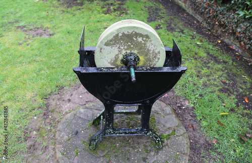 фотографія An old grindstone in an cast iron stand situated in a garden in Wales, UK