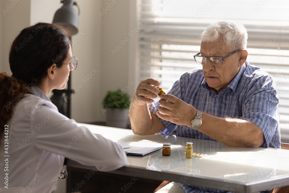 Effective medication. Focused old man pensioner in glasses examining bottle with pharmaceuticals medicinal drugs at therapist office. Aged male gp patient get new prescription to cure chronic disease Effective medication. Focused old man pensioner in glasses examining bottle with pharmaceuticals medicinal drugs at therapist office. Aged male gp patient get new prescription to cure chronic disease