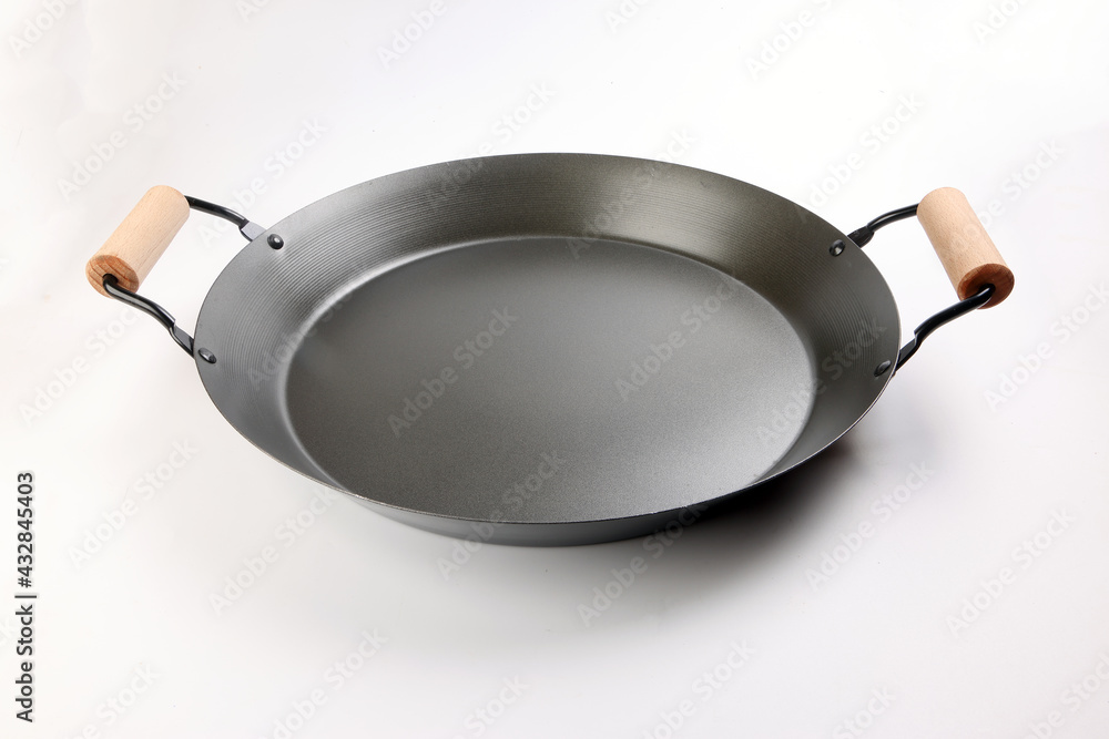 Cast metal not stick two wooden handle empty flat bottom frying pan on white background Cast metal not stick two wooden handle empty flat bottom frying pan on white background