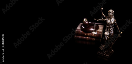 Legal and law concept statue of Lady Justice with scales of justice, gavel and law books black background