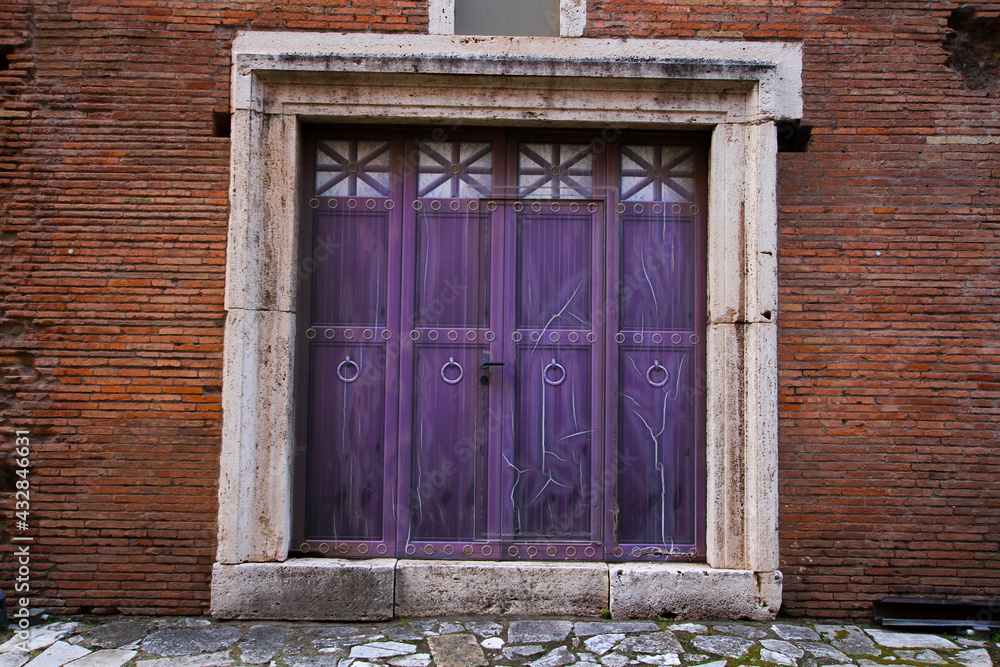 Purple wooden door, with ancient marble uprights, located at the Mercati Traianei in Rome