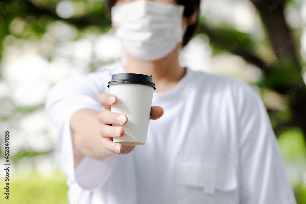 温かい飲み物を差しだす人 温かい飲み物を差しだす人