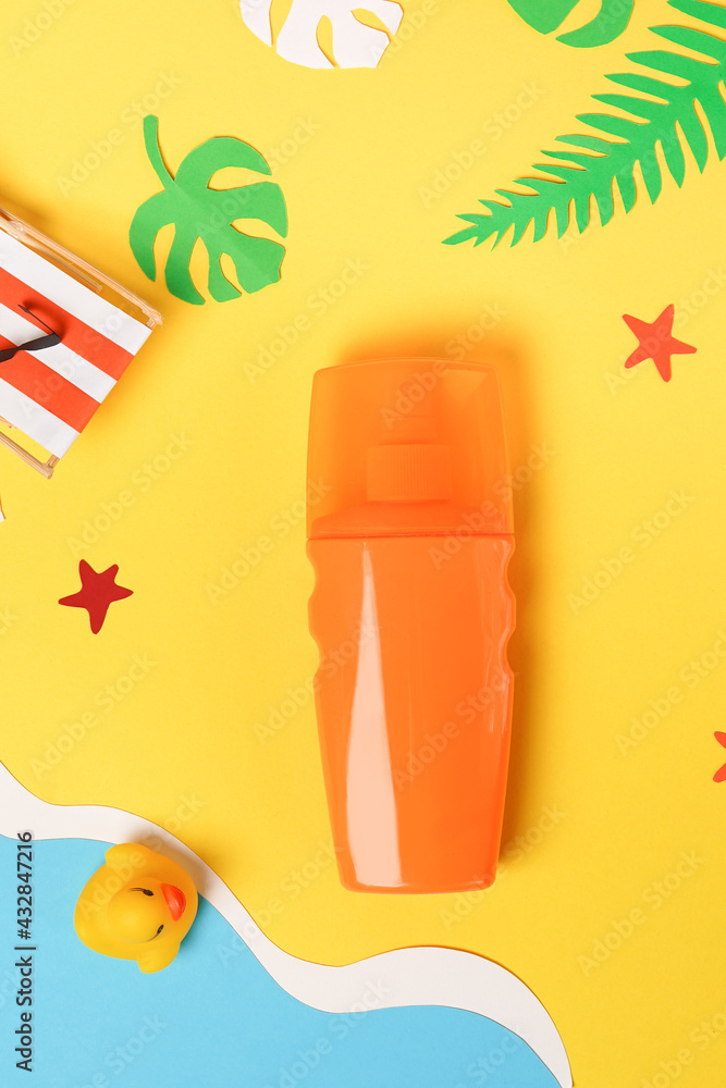 Summer beach - suntan oil bottle on yellow sand with paper accessories Summer beach - suntan oil bottle on yellow sand with paper accessories