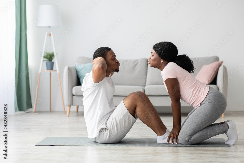 Sporty black man and woman exercising together at home Sporty black man and woman exercising together at home