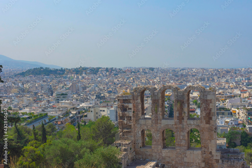 Obraz premium Ancient Odeon of Herodes Atticus Roman theater under the ruins of Acropolis, with view over the city of Athens, Greece, in summer sunny day