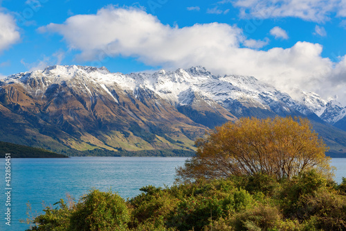 Lake Wakatipu in the South Island of New Zealand in autumn, with the snowy mountains of the Southern Alps in the background