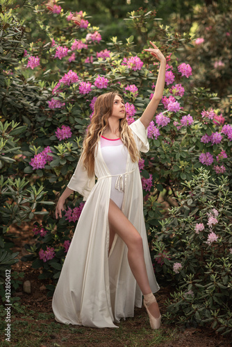 beautiful girl ballerina in a blooming lilac garden. girl with flowers